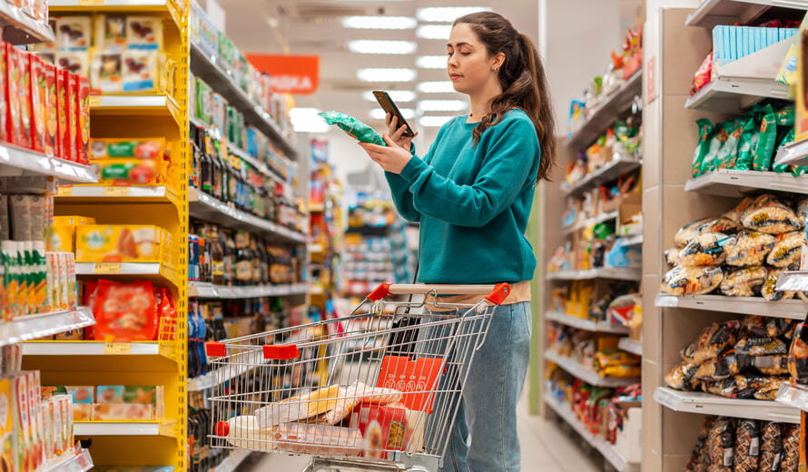 woman on her phone in grocery aisle